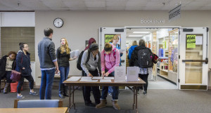 students filling out rental forms while waiting to enter bookstore